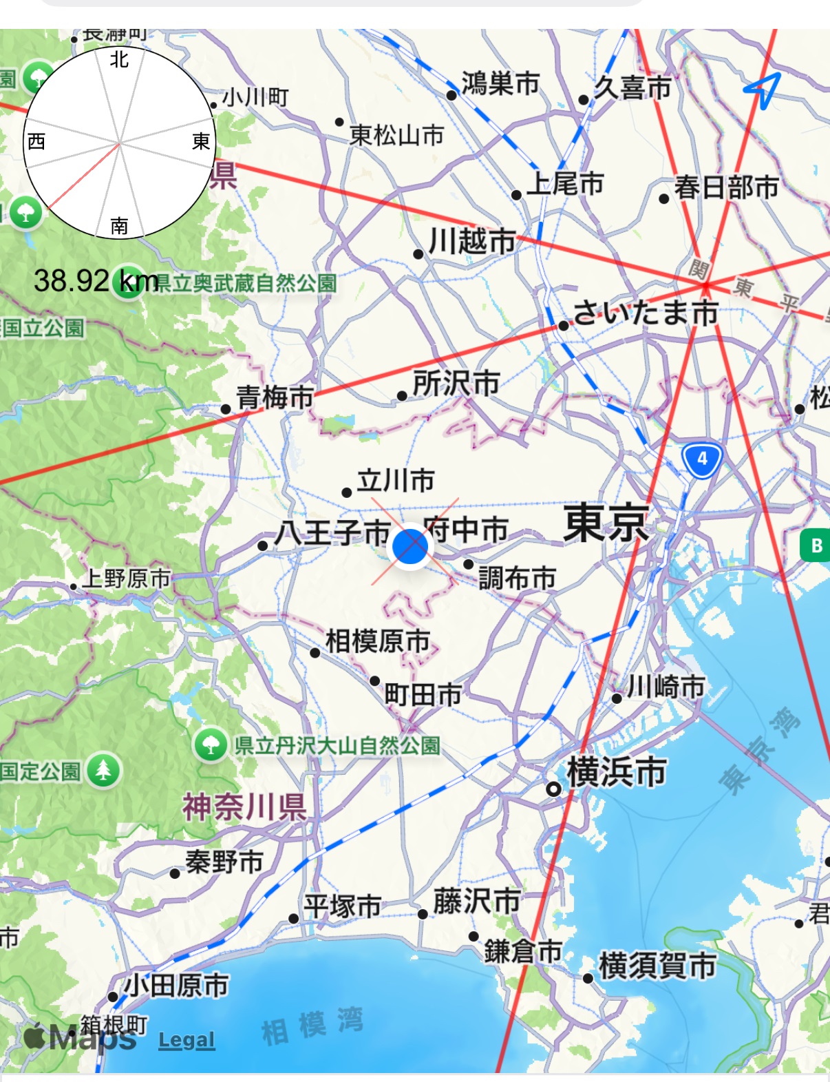 スマートフォンアプリ「あちこち方位」のスクリーンショット。関東地方(東京・神奈川・埼玉)の地図上に自宅からの赤い方位線が引かれており、約38.92km離れた東京都多摩地域付近にある現在地(青い丸アイコン)を示している。